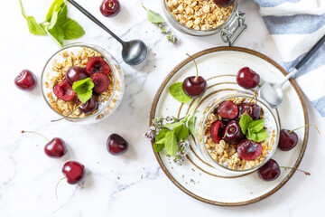 Poster - Healthy menu concept. Home made granola breakfast. Glass of parfait made of granola, berries cherry, yogurt with chia seeds on rustic table. View from above.