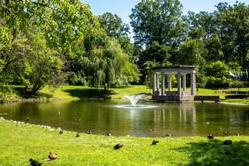 Saratoga Springs, NY - USA - Aug 3, 2022 Horizontal view of historic Congress Park, a park with landscaped grounds, statuary, fountains and historic former casino building in Saratoga Springs.