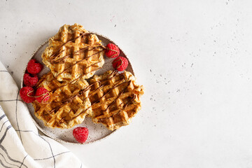 Wall Mural - Belgium waffles close up with chocolate sauce and raspberry flat lay,