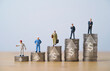Worker and businessmen miniature figure standing on increasing coins stacking with up arrow and dollar sign for income salary various growth in different position , Human development concept.