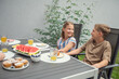 © spass - Teen brother and suster having breakfast outdoors