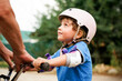 © Anna - Grandfather teaching little child riding a bike. Toddler boy wearing safety helmet  learns cycling.
