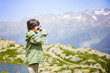 © Anna - Young boy doing hiking, staying in a mountains, holding travel tumbler and drinking tea.