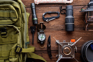 outdoor travel equipment planning. camping trip on wooden table background.