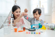 © Supachai - Asian mother and little boy making chemical experiments and tests in living room at home.Home laboratory education science concept for kids.