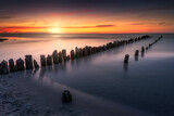 Fototapeta Fototapety z morzem do Twojej sypialni - Baltic see, sunset over beach. Plaża Dębki. Wakacyjny zachód słońca nad morzem bałtyckim z widokiem na falochron i delikatne fale
