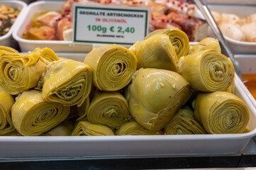 Wall Mural - Pickled and grilled heads of fresh organic artichoke flowers, edible vegetables green artichokes, English translation is Grilled artishokes in olive oil