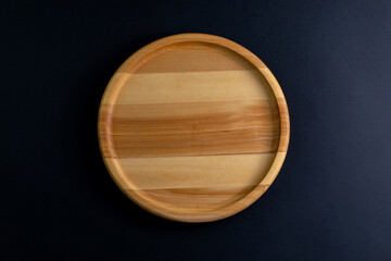 a circle wooden food stand on a dark background top view