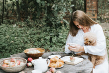 Young Woman Model Plus Size In White Dress Sit At Table With Pet Dog Poodle, Resting And Drinking Tea After Harvesting Autumn In Back Yard, Fall And Harvest, Zero Waste Life, Eco-friendly Simple Life