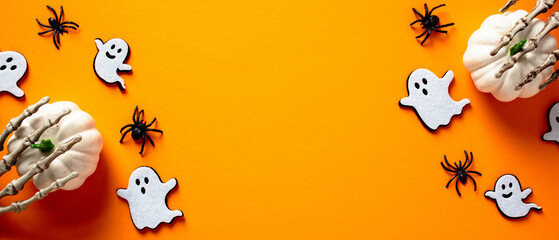 halloween banner with cute decorations, pumpkins, ghosts, skeleton hands, spiders on orange backgrou