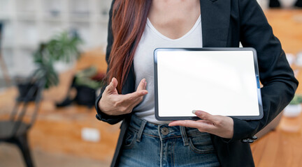Wall Mural - businesswoman showing blank screen digital tablet, standing in office.
