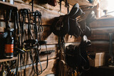 Lather horse equipment hanging on wall in stable
