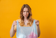 Young Displeased Woman Wearing T-shirt Posing With Trash Bag