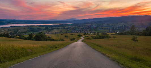 Wall Mural - road running through mountain landscape during spectacular sunset