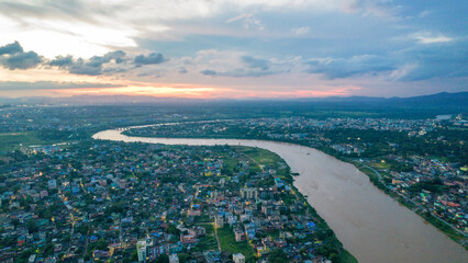 Wall Mural - Aerial view of Indian city with river during sunset