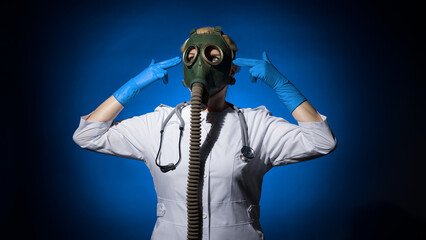 doctor woman in a gas mask put her hands in the shape of a gun to her head temple and looks up on a blue background