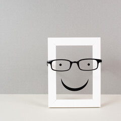 Wall Mural - Frame with a happy face with eyeglasses, mental health concept, positive mindset and emotion, support and evaluation symbol