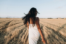 Woman With Tousled Hair Walking At Wheat Field