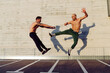 © ADDICTIVE STOCK - Young men practicing fly kick outdoors
