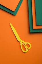 Scissors On Green And Orange Cardboard Background