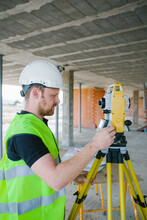 Surveyor Engineer Working At Construction Site With Measuring Eq