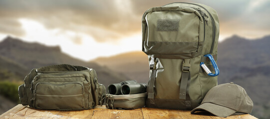 Wall Mural - Green bag and backpack and landscape of mountains. 