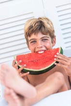 Cheerful Boy Eating Juicy Watermelon In Summer