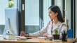 © amnaj - Beautiful Asian businesswoman using her laptop enjoys working, taking notes, reviewing assignments and enjoy reading.