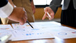 © bongkarn - Close-up hands, A businessman meeting and discussing a financial plan with his group