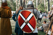 Knights of war preparing for battle in forest outdoors. Back view of viking in helmet, chain mail with round shield on back. Middle Ages concept