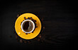 © stockyme - Yellow coffee cup top view on dark table - concept of breakfast and fresh aroma of morning routine