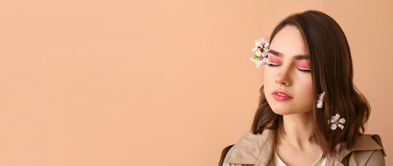 Poster - Beautiful young woman with spring flowers in hair on beige background with space for text