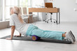 © Pixel-Shot - Mature physiotherapist training with foam roller in rehabilitation center