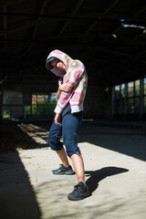 Wall Mural - Young female hip hop dancer dancing and jumping in abandoned building on a sunny summer day	
