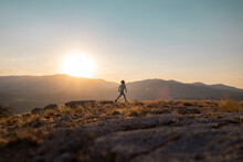 Silhouette Of A Running Man Against The Background Of The Sky And Sunset In The Mountains, Sports And Recreation.