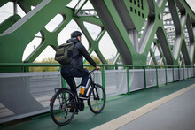 Rear View Of Businessman Commuter On The Way To Work, Riding Bike Over Bridge, Sustainable Lifestyle Concept.