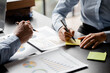 © kamiphotos - Company meeting room has businessmen and finance managers meeting together on finance topics, they are looking at information on documents and discussing together. Concept company financial management