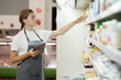 female staff standing in front of the supermarket shelf with milk using tablet pc