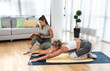 © Srdjan - Young fitness and yoga instructor working in your home. Sporty educated woman helping young girl at her apartment at in home workout and training for healthy life.