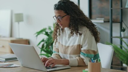 Wall Mural - Video of concentrated beautiful business woman working with laptop in living room at home.