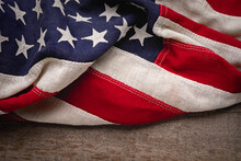 Vintage American Flag Draped Across A Rustic Wooden Background