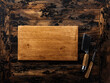 Rustic kitchen background. Wooden chopping board and vintage knife, fork