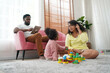 © FotoArtist - Shot of happy interracial family of mother father and their daughter inside modern apartment.