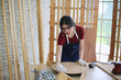 © FotoArtist - Side view portrait of modern female carpenter measuring wooden part making furniture over working table in workshop