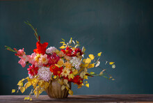 Autumn Bouquet With Red And Yellow Flowers In Ceramic Vase On Dark Background
