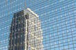 A distorted reflection of a building in the glazed facade of another building.
