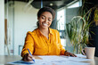 © Prostock-studio - Happy black female company worker working with documents, writing and doing paperwork, sitting at workplace in office