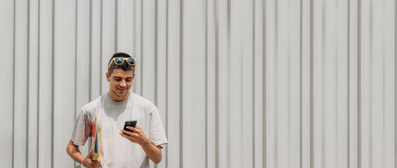 Canvas Print - student with books and mobile phone in the street