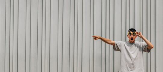 Wall Mural - young man on the street isolated on background pointing