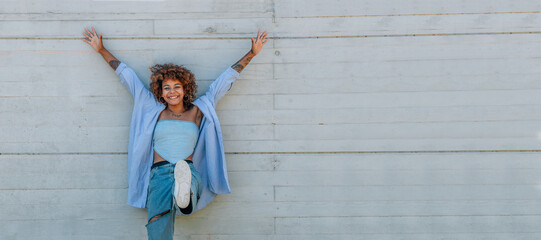 Wall Mural - happy funny girl smiling on the street isolated on wall